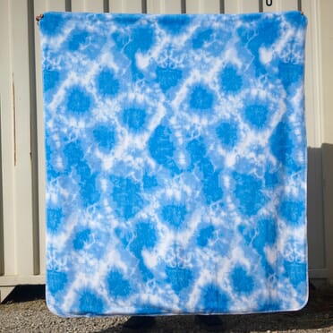 https://static.yourfleece.com/catalog/product/d/x/dx-2681-1a-1-b_shibori_tie_dye_blanket.jpeg?quality=80&canvas.color=ffffff&scale.option=fill&scale.width=372&scale.height=372